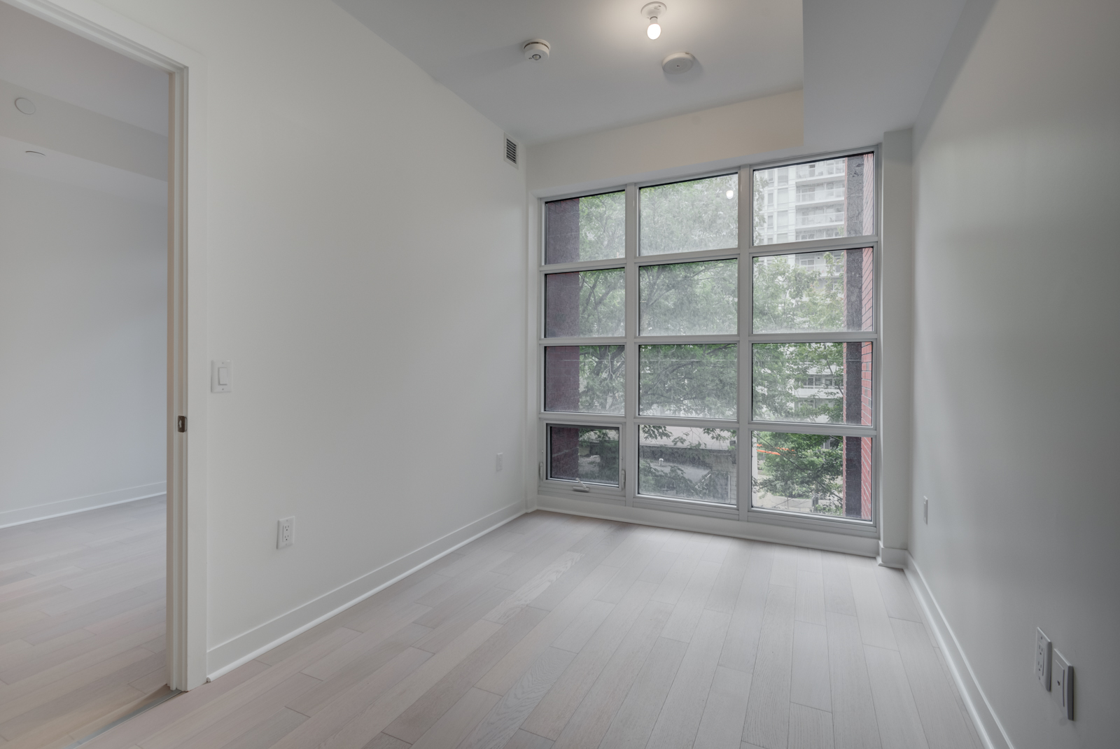 Empty master bedroom with floor-to-ceiling windows.