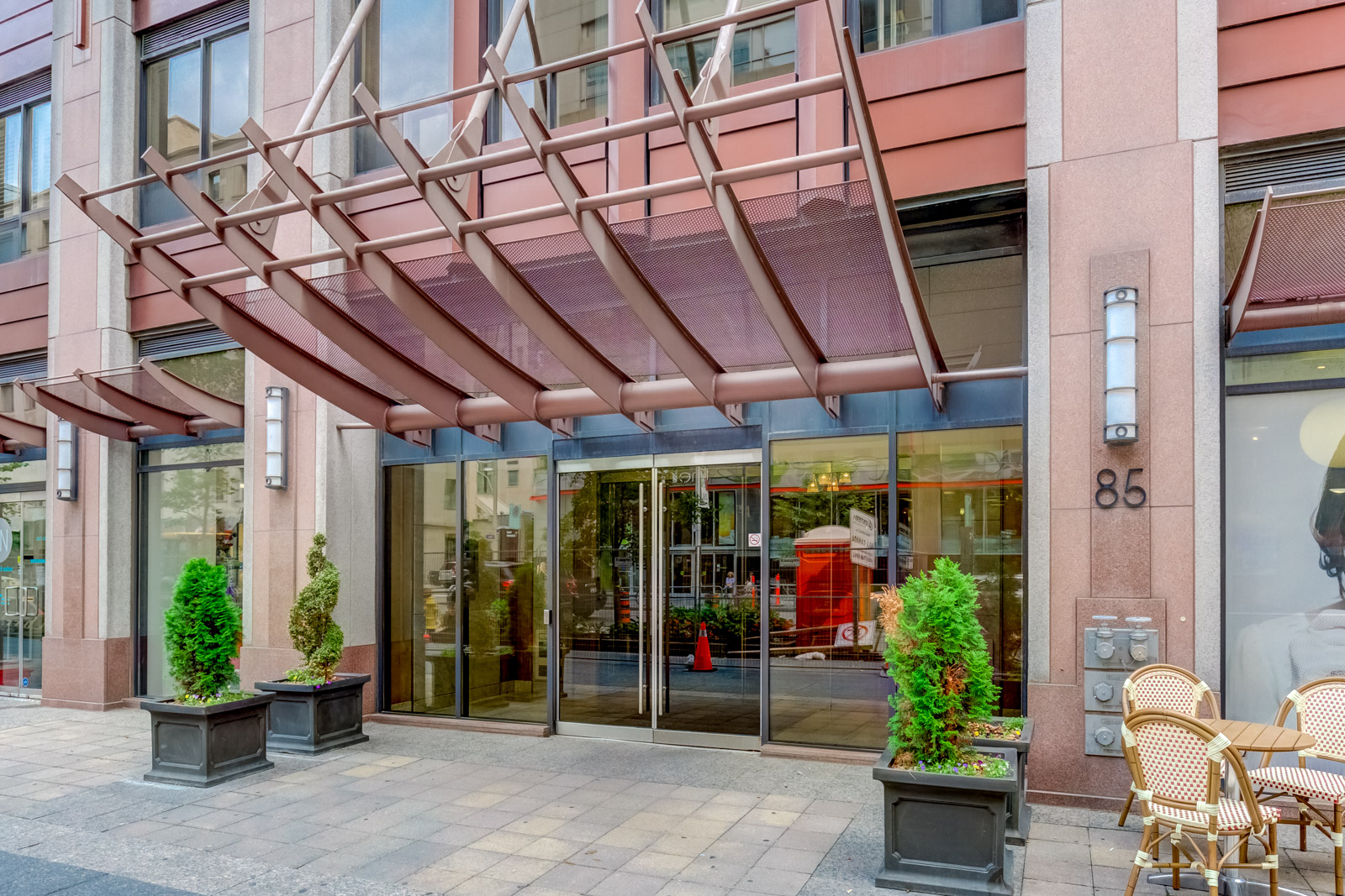 85 Bloor Street E condo entrance with stylish pink awning.