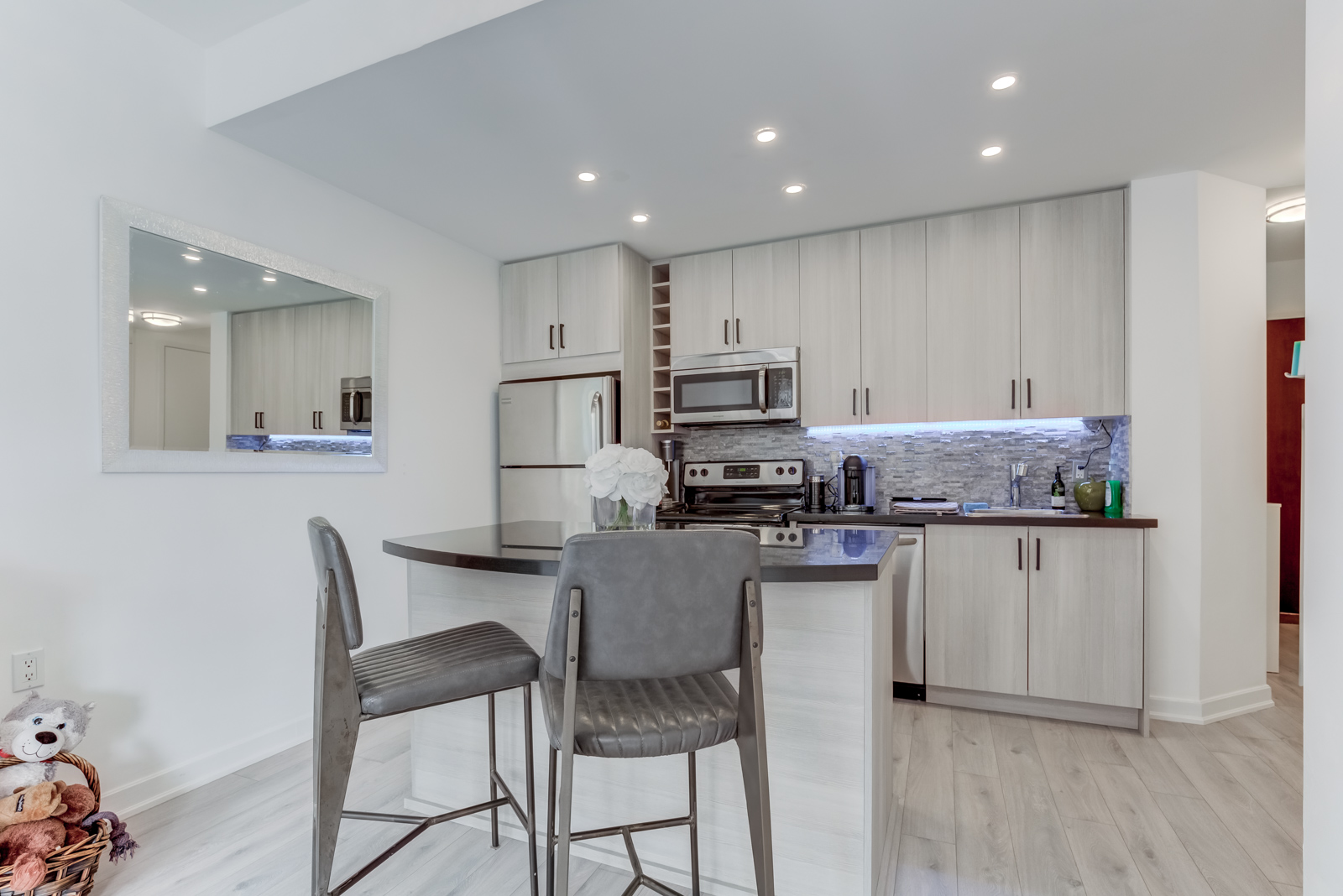 Kitchen island with curved edge and two high chairs.