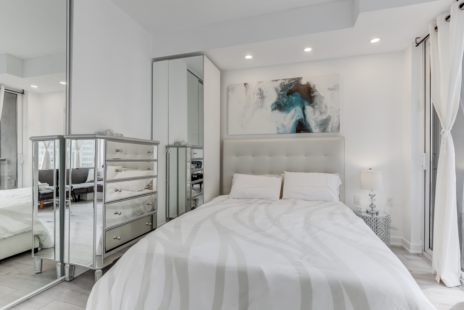 85 Bloor Unit 1814 chic master bedroom with silver armoire, tall closet with mirror doors and potlights.