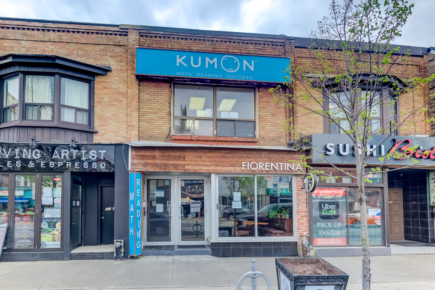 Brown brick and wood exterior of 463 Danforth Ave in Toronto.