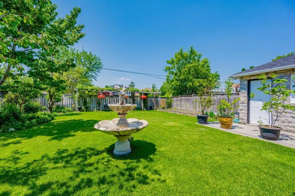 30. Backyard with fountain trees shrubs garden plots high fence