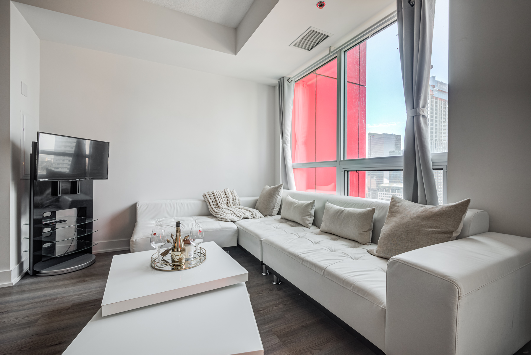 Living room with gray sofa, table and red wall in background.