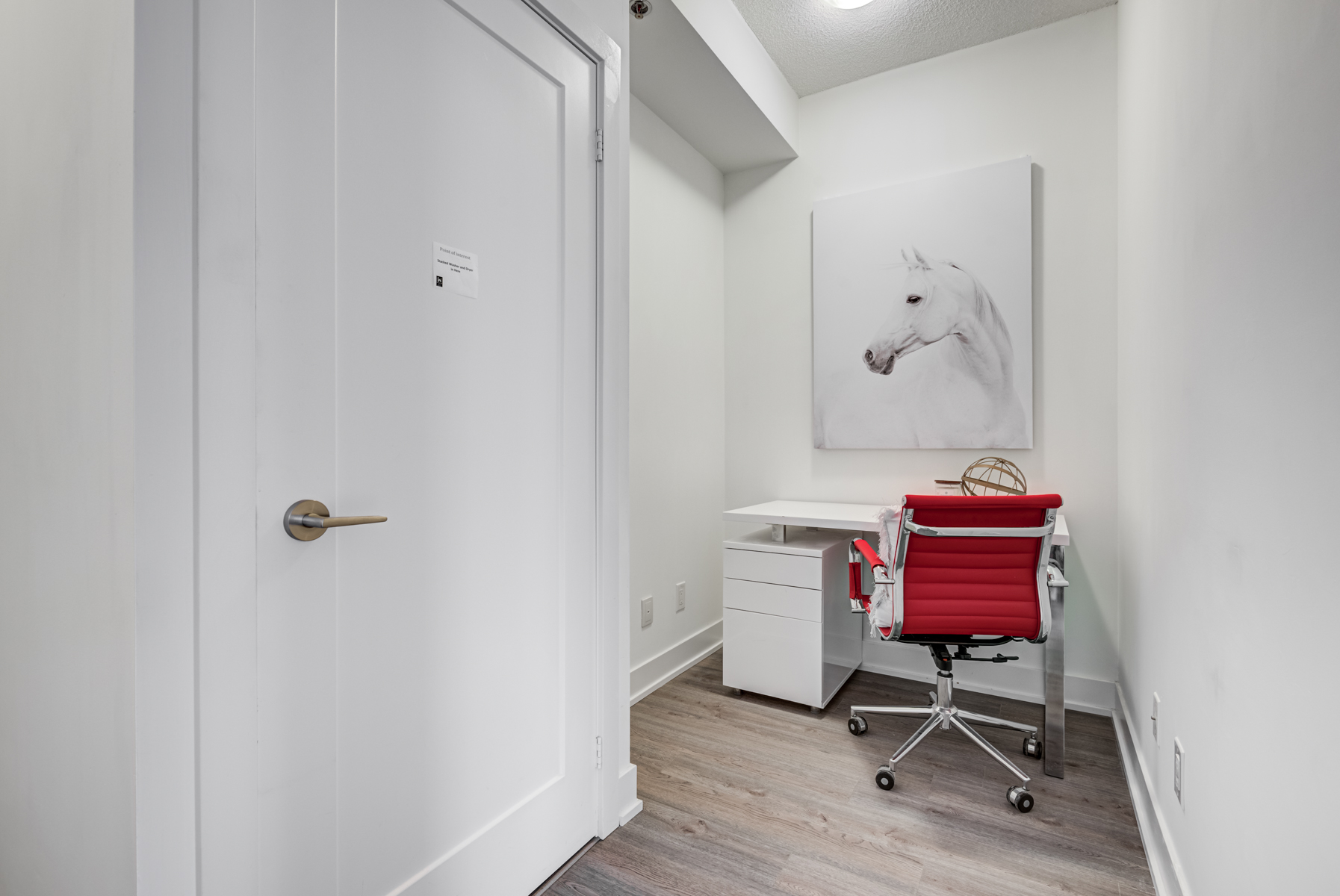 Den being used as a home office with chair, desk and painting of horse.