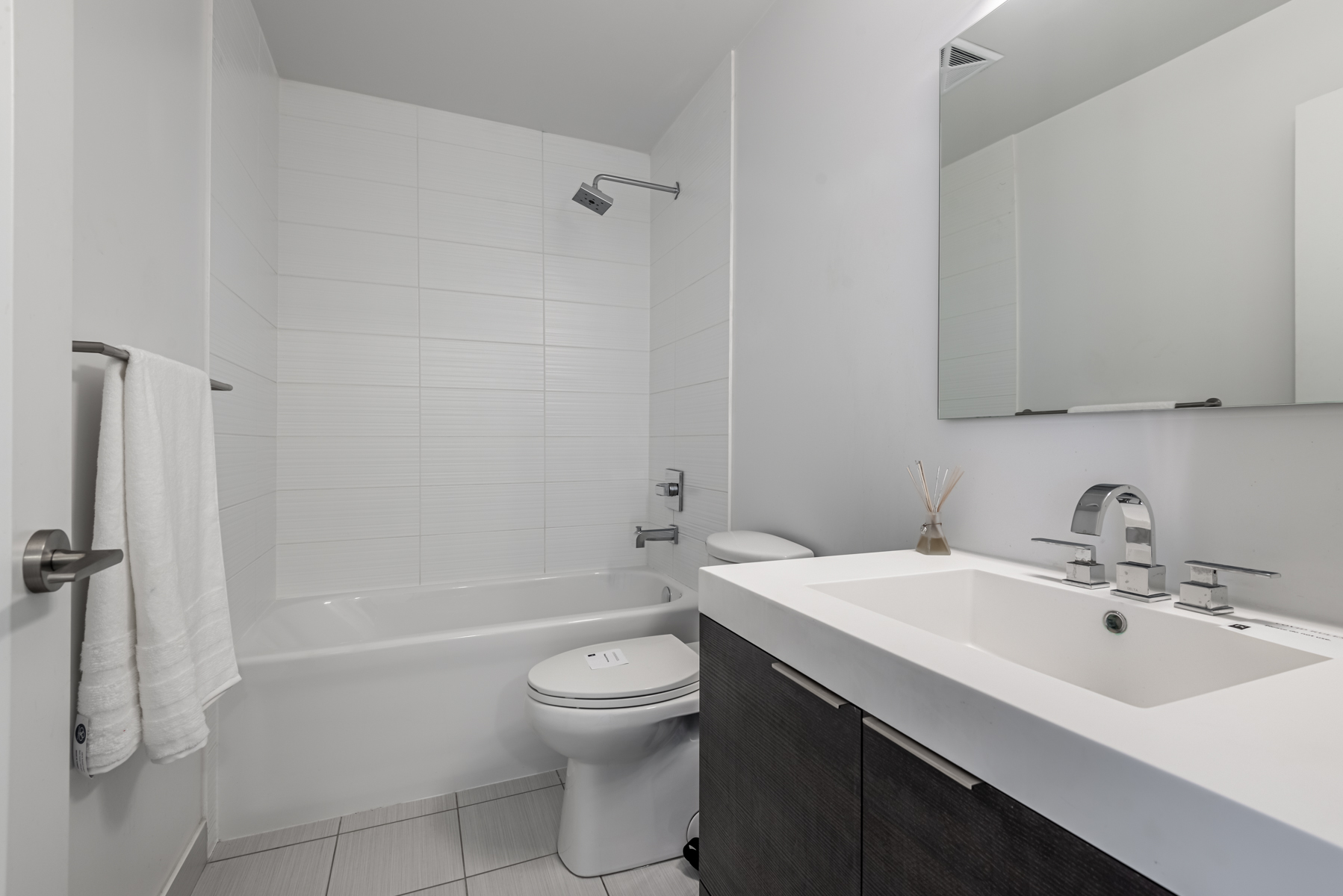 Bathroom with gray walls, white quartz counter and large vanity.