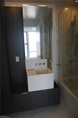Image of 1 Bloor Unit 3809 master bath, with sink, cupboards and shower.