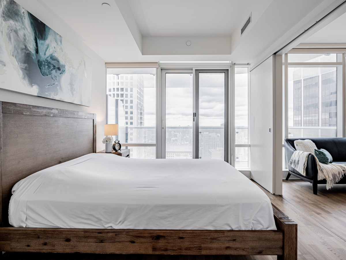 Condo bedroom with walk-out balcony.