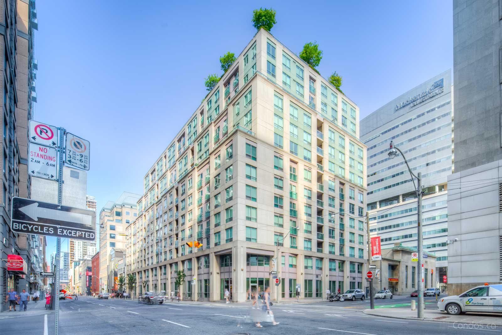 13-storey Qwest Condos, a white building with blue windows, from across the street.