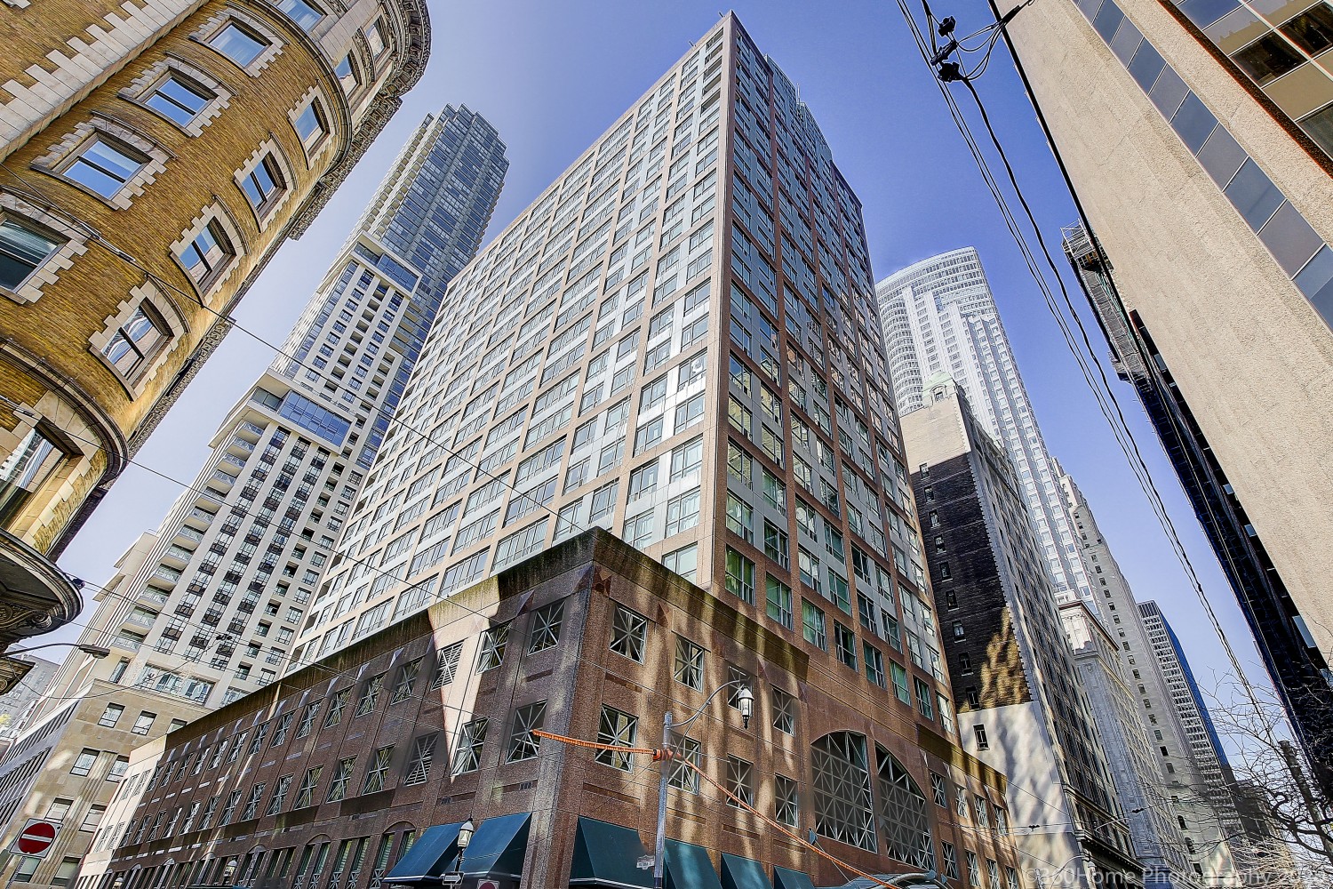 Looking up at The Metropole, a rectangular condo with a brown-brick base.