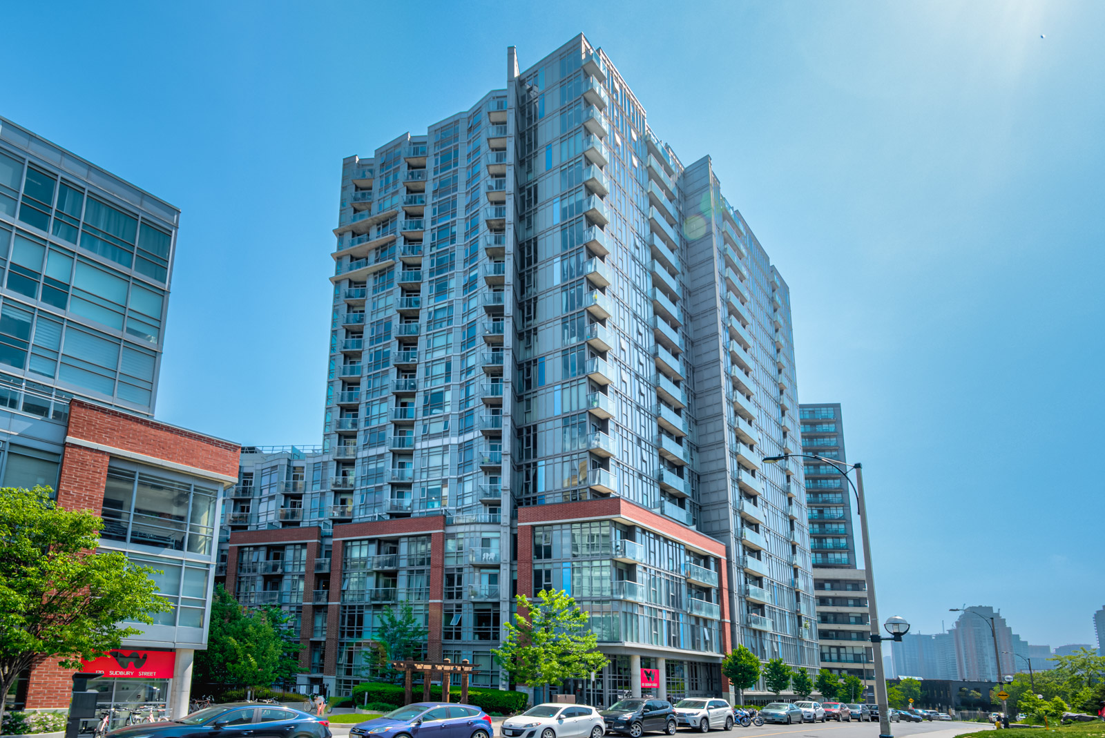 Street view of Westside Gallery Lofts, a 20-storey condo of blue glass and steel.