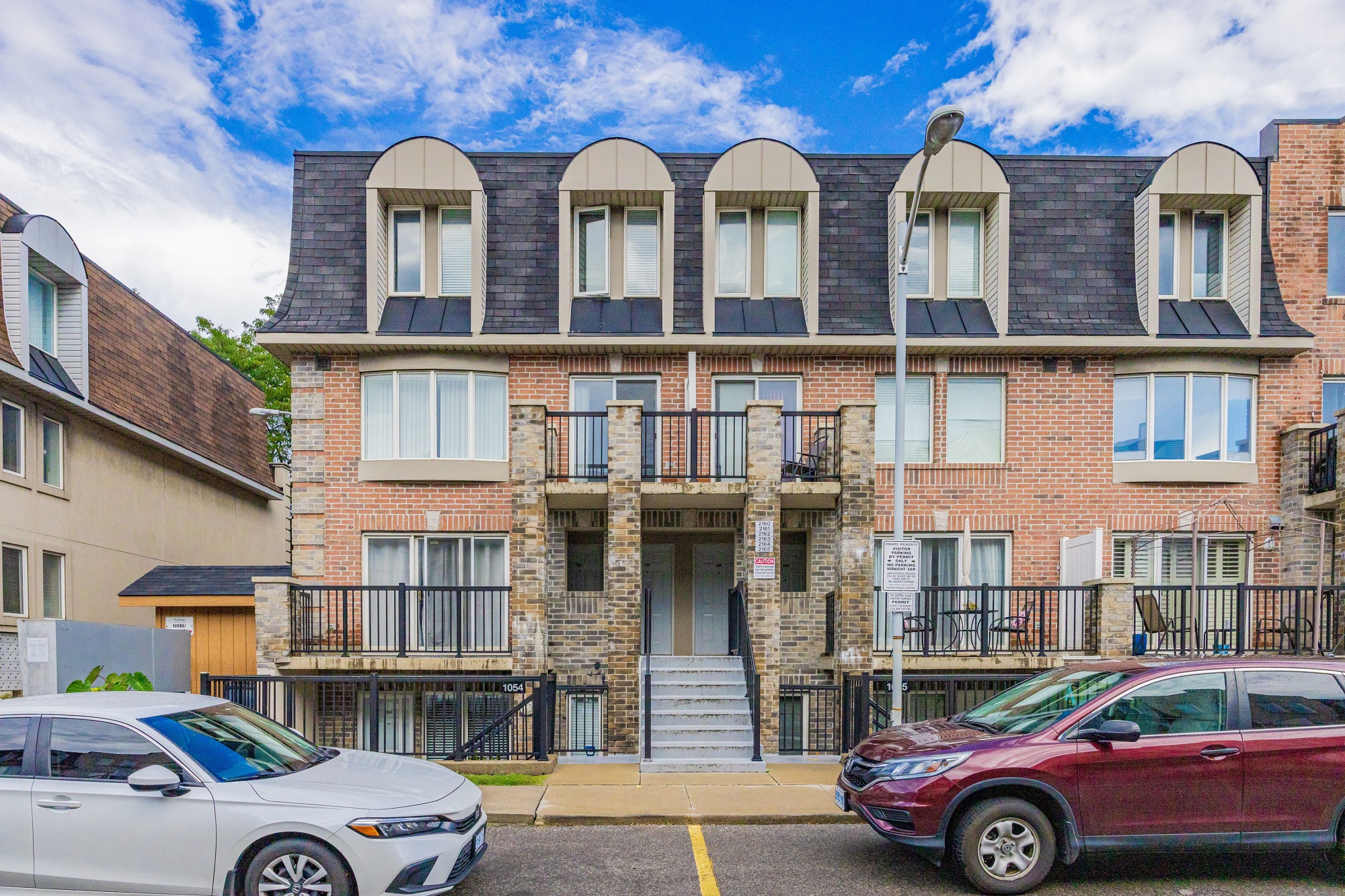 Exterior of 2 storey red brick townhouse.