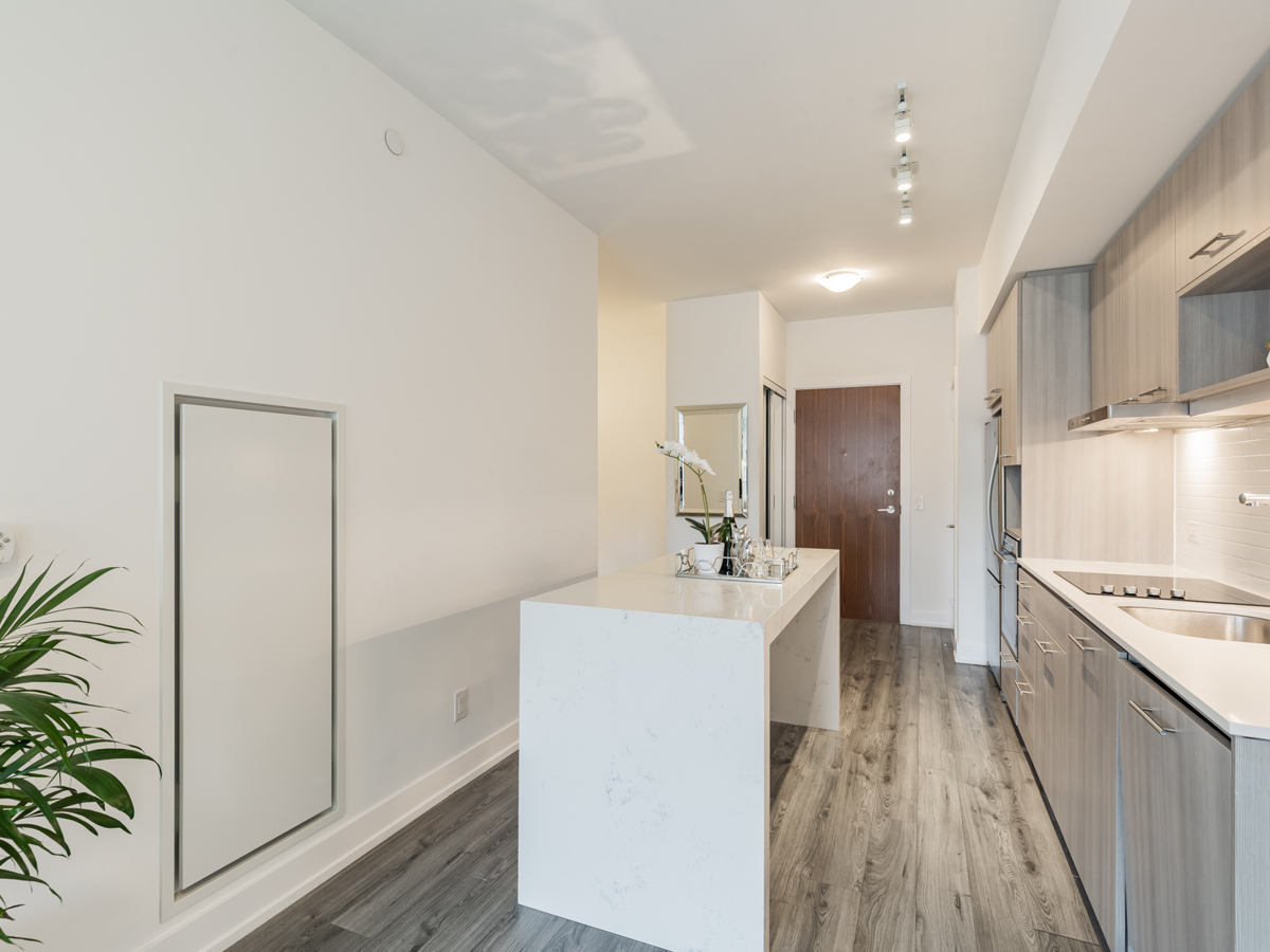 Custom-made white quartz island in condo kitchen.