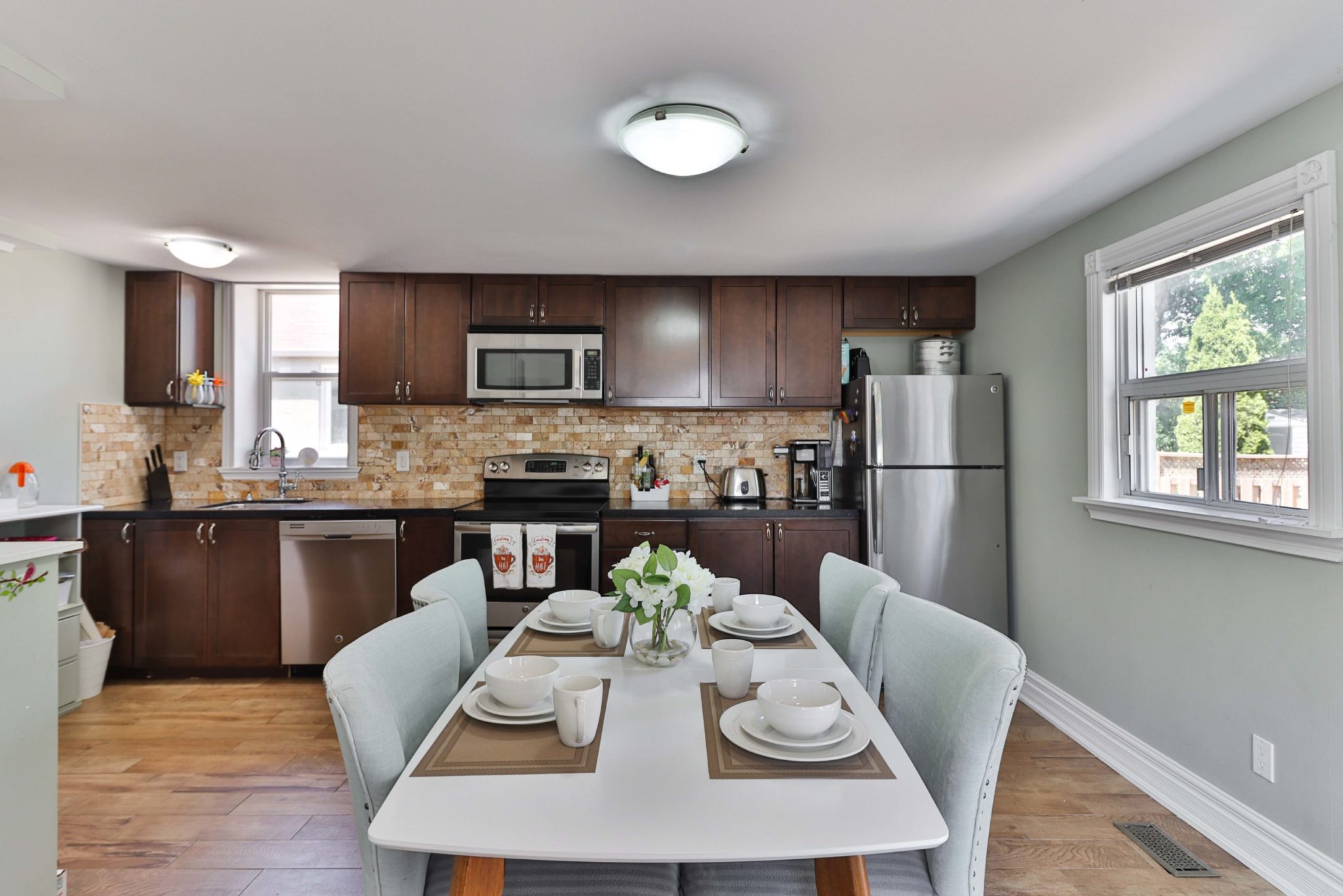 Dinette set with table and chairs with kitchen in background.