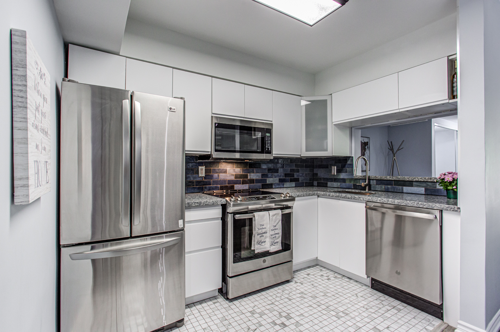 5 Everson Dr kitchen with gray cabinets, dark blue brick back-splash, and marble floor tiles.