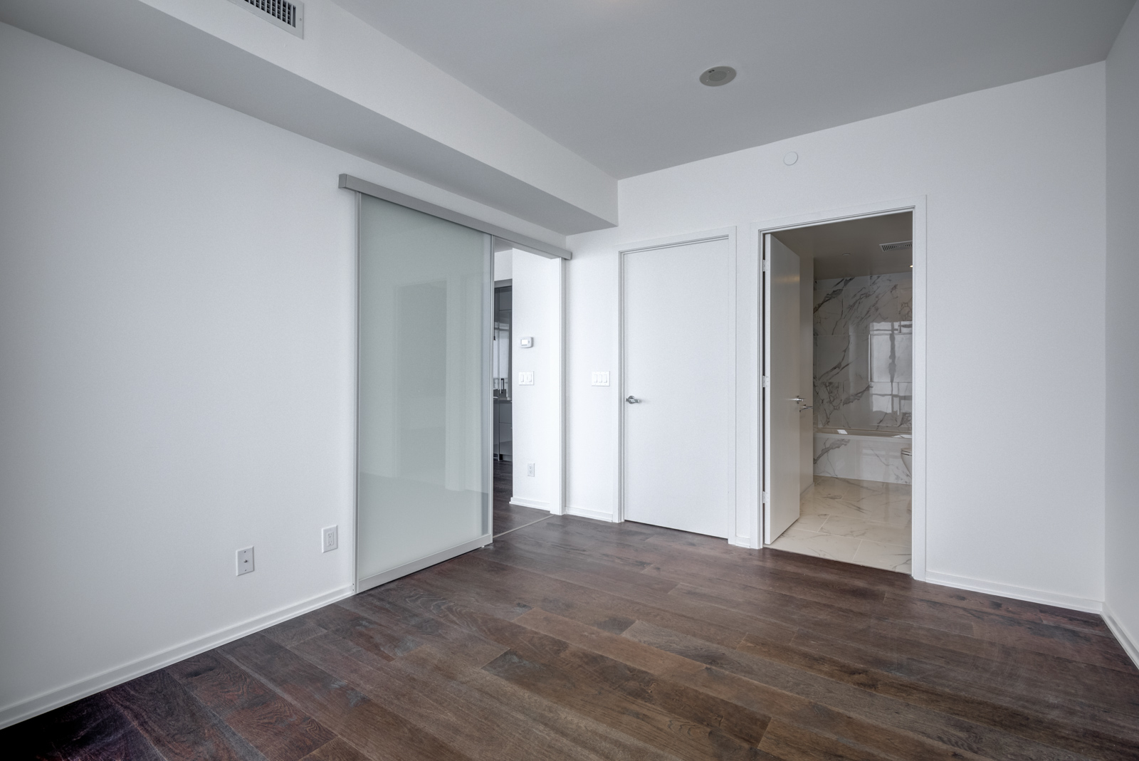 Sliding doors connect the master bedroom to the living and dining areas.