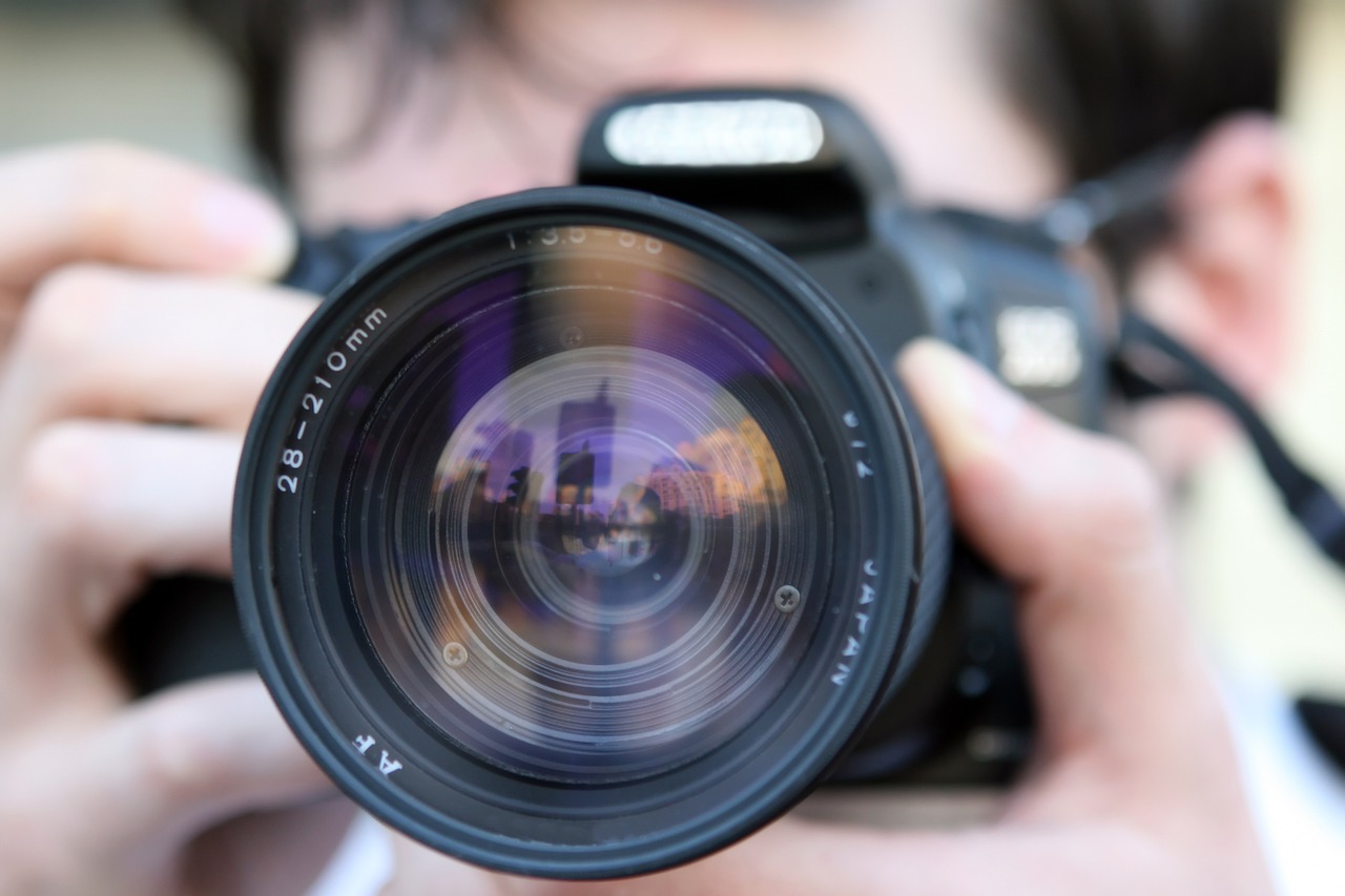 Professional photographer and Camera lens up close.