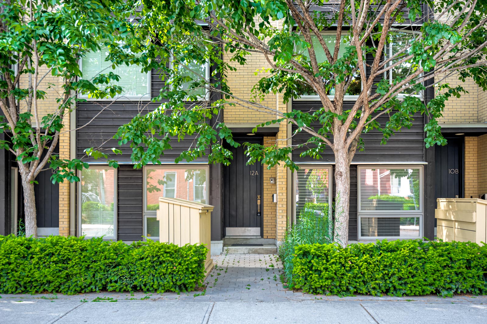 Exterior of 12A Cecil, a dark brick house with white windows.