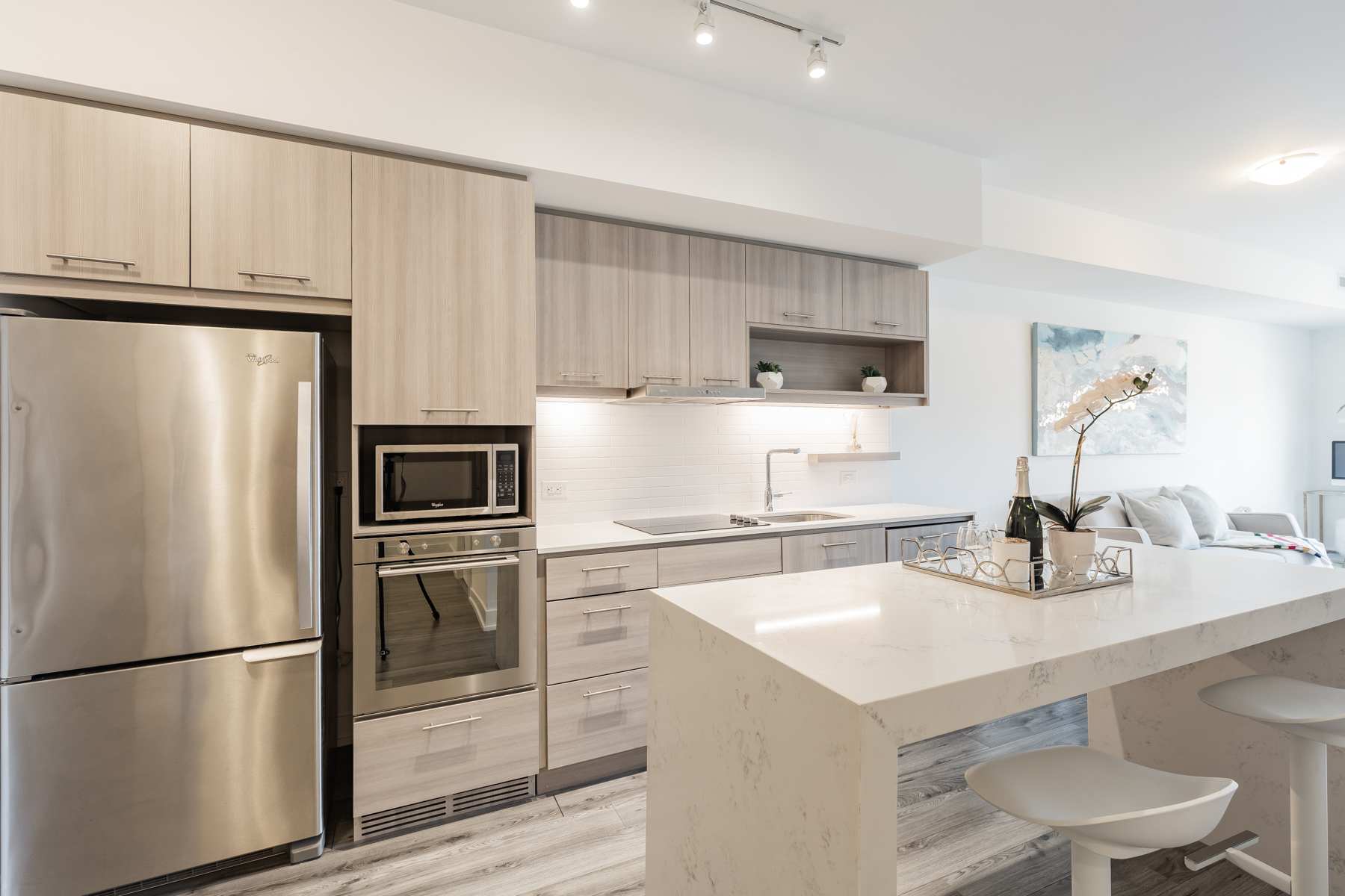 Contemporary condo kitchen with wood cabinets and white counters.