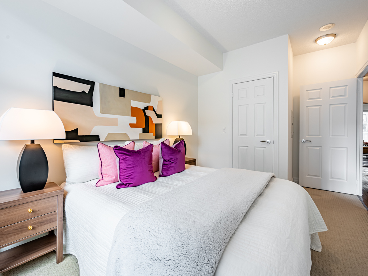 Condo bedroom with large bed and 2 side tables.