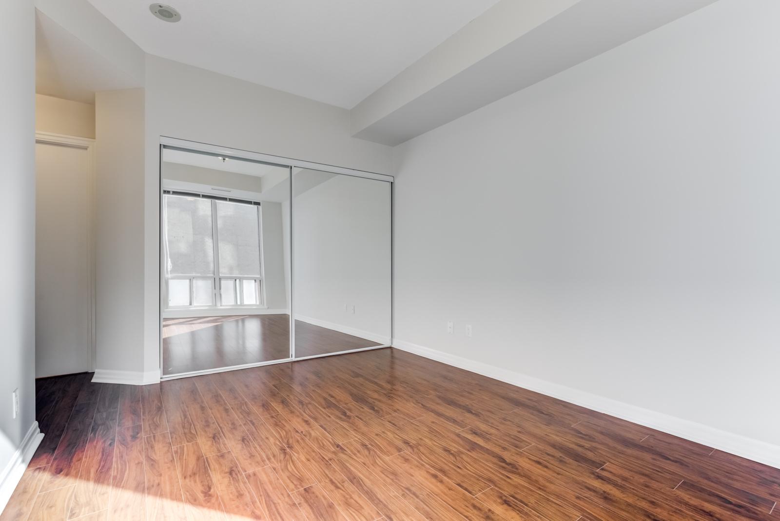 Closet with closed mirror doors in master bedroom at 300 Bloor St E Unit 1809 in Toronto.