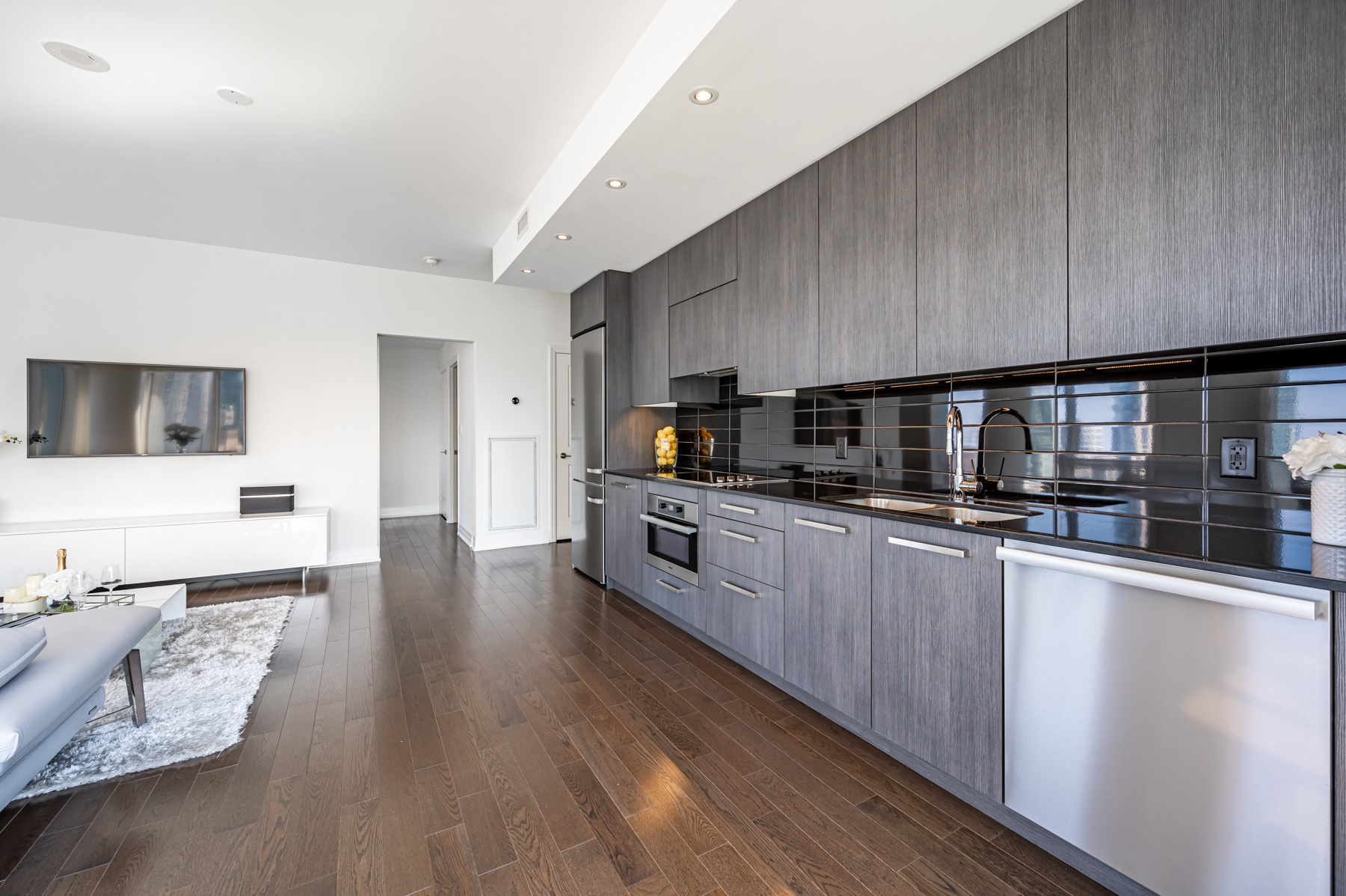 Long condo kitchen with several big cabinets and drawers.