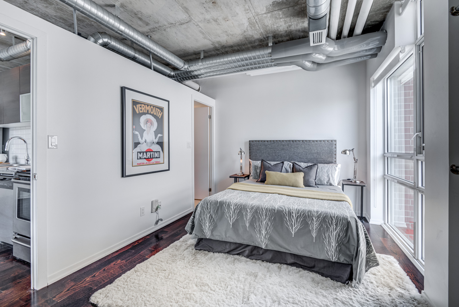 Queen-sized bed in industrial-style master bedroom of 150 Sudbury St #511.