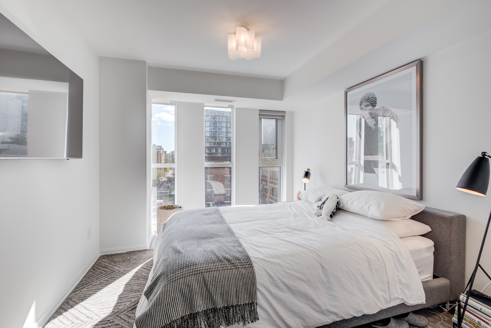 Sunny gray and white master bedroom with large bed.