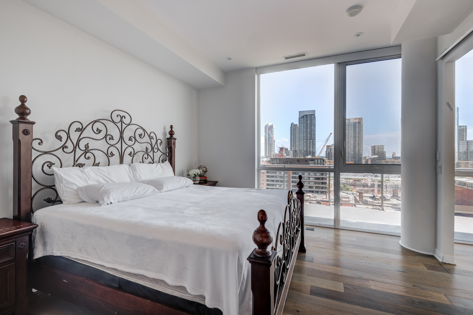 Window view of master bedroom and bed at Victory Lofts Penthouse Suite in 478 King St W Toronto.