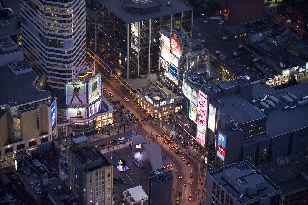 Aerial view of Yonge and Dundas in Toronto during night with electric billboards, buildings and pedestrians.
