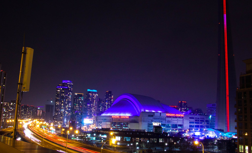 Toronto's Rogers Centre at night with blue dome and red lettering.
