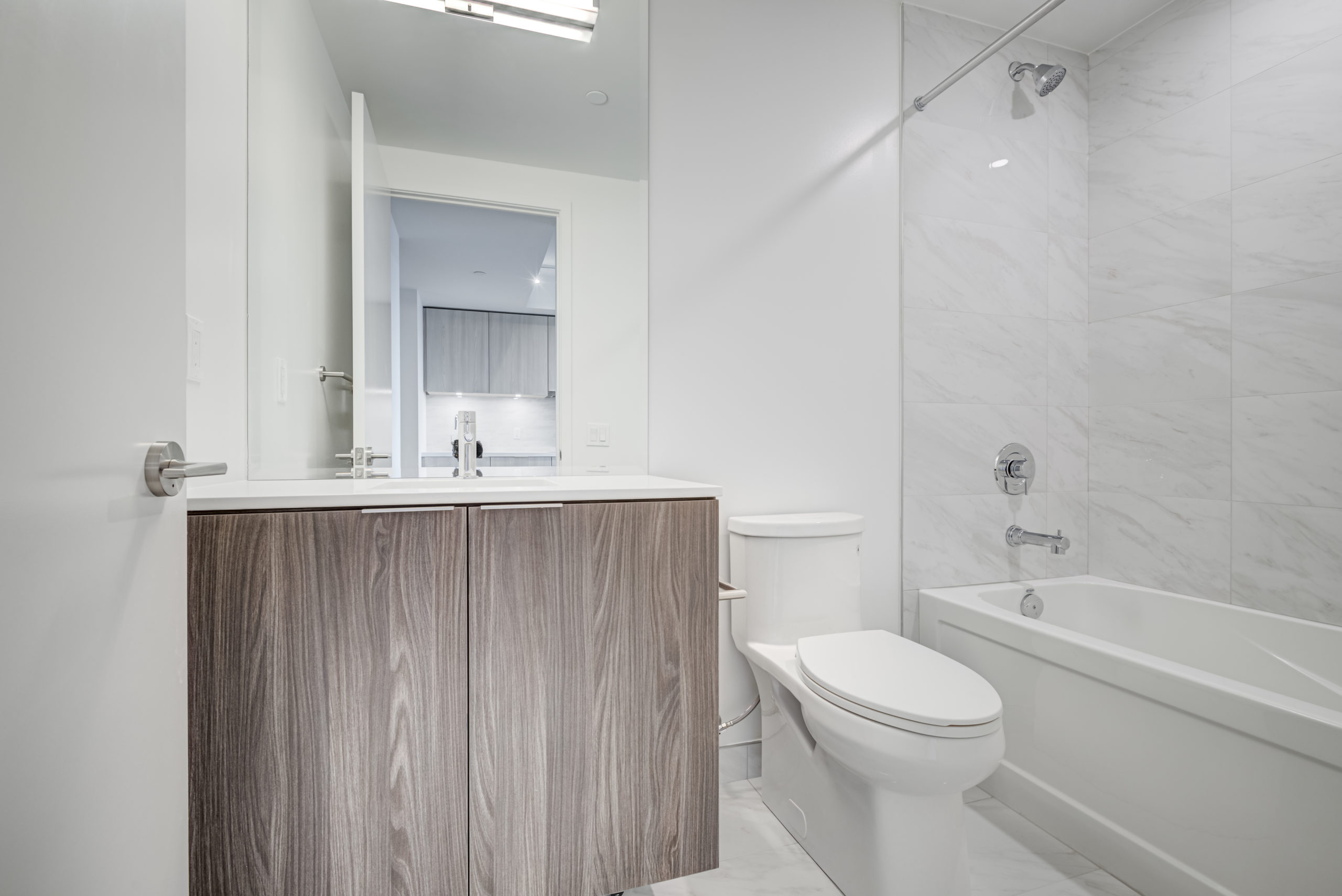 4-piece bath with marble tiles, ceramic floors, brown cabinets.