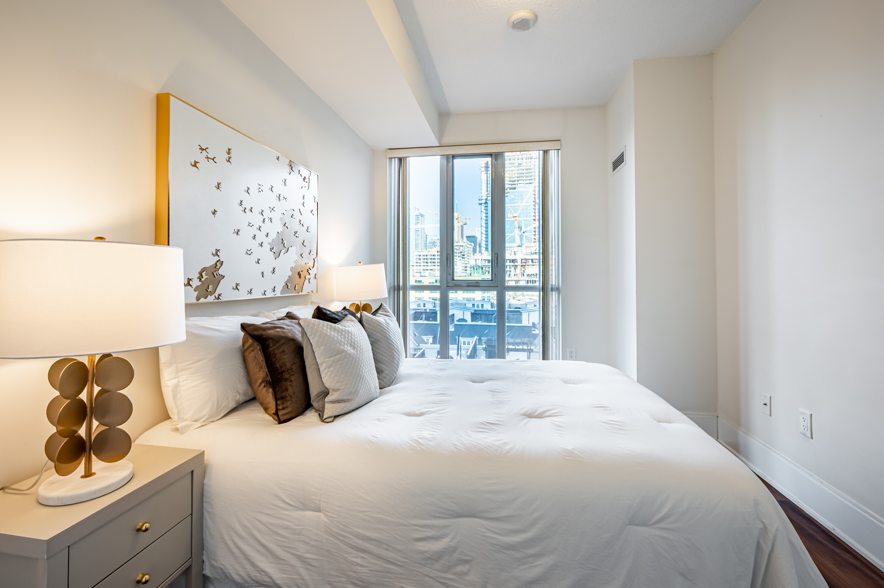 Large white bed and floor-to-ceiling windows.