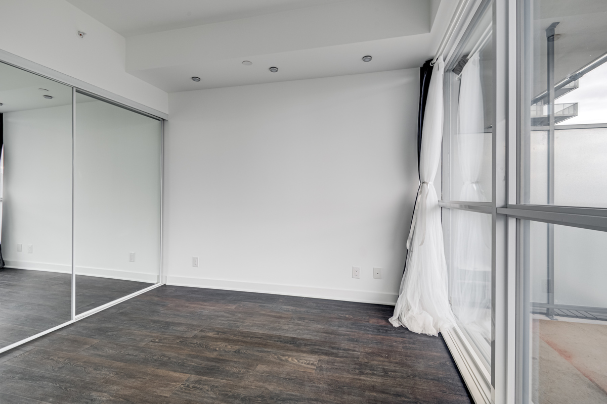 15 Grenville St Unit 4101 master bedroom with mirror door closet and dark floors.