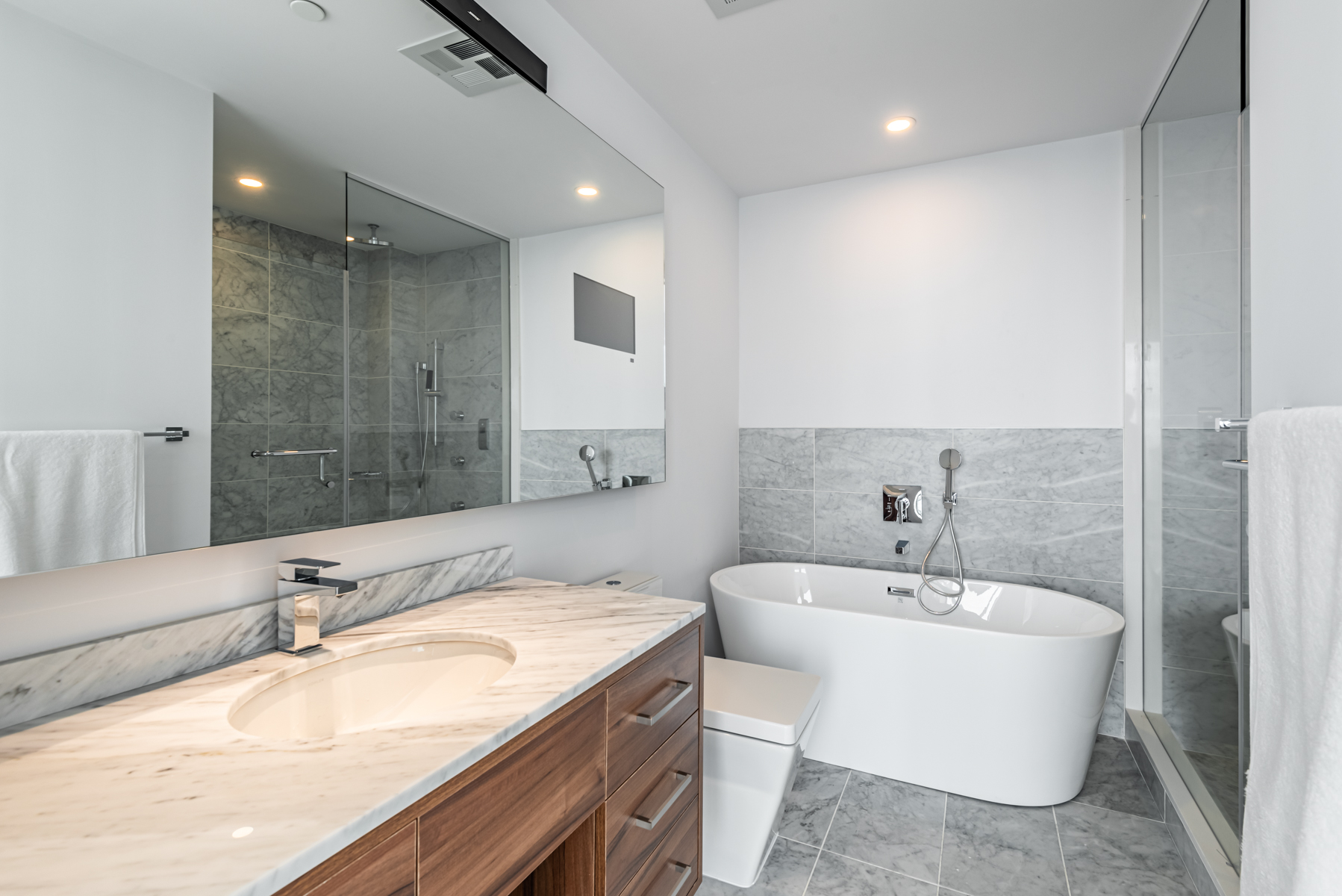 488 University Ave #3102 master bath with marble tiles, granite counters, long mirror and big tub.