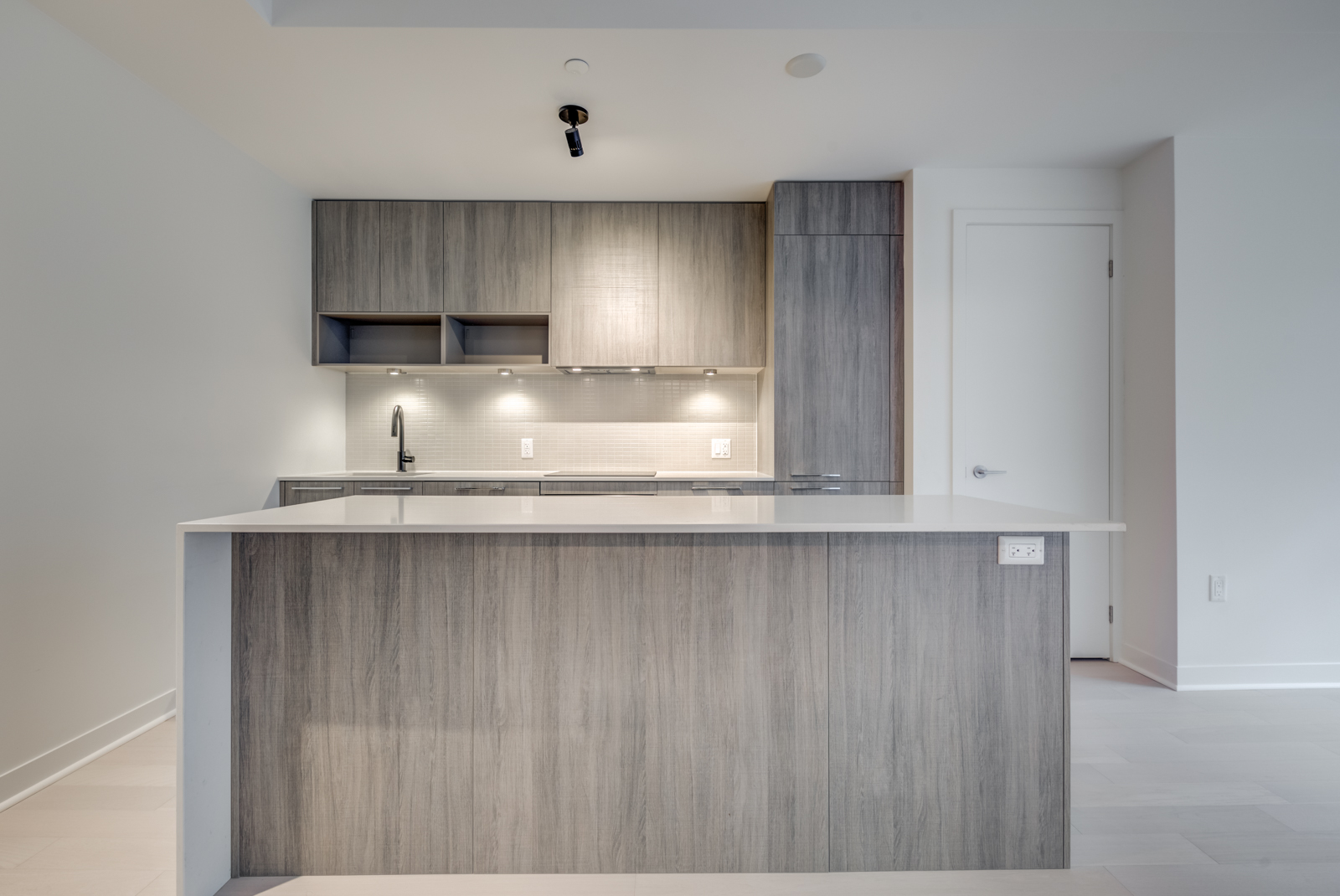  Centered view of kitchen island in foreground and cabinets in background.