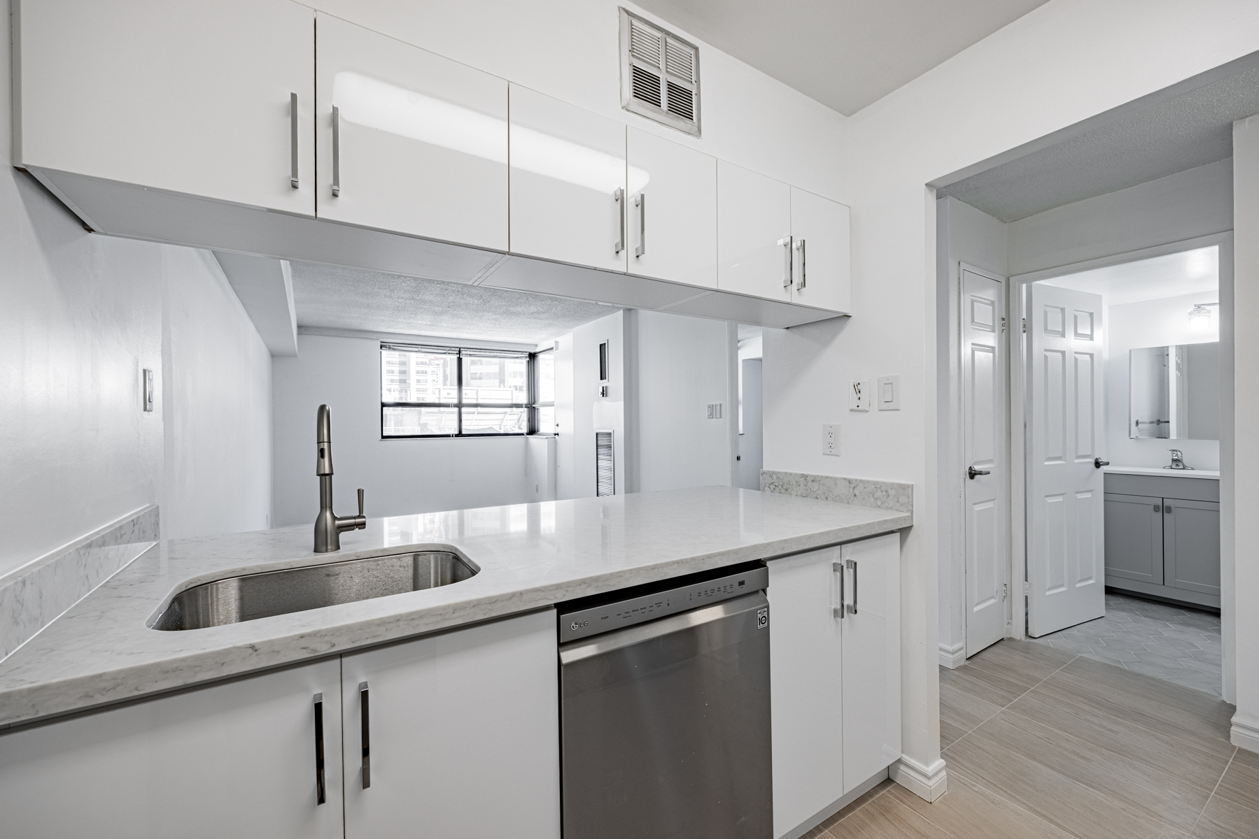 Condo galley kitchen with wall and floor-level cabinets.