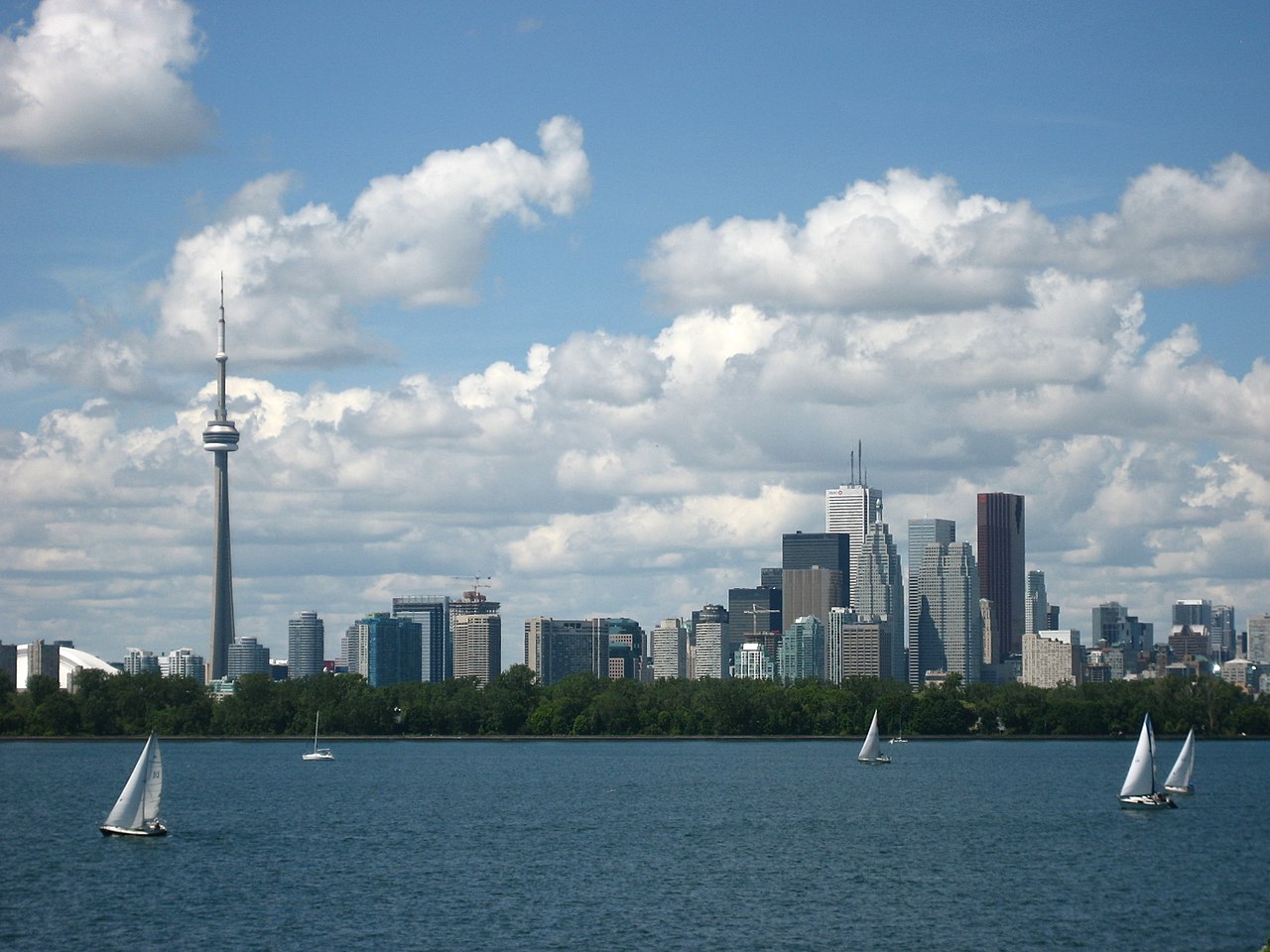 Photo shows Toronto Waterfront from Lake Ontario. In addition to the CN Tower, we can also see boats and so many buildings. Therefore, in conclusion it seems like, maybe, probably, which almost, most of all, most noteworthy, especially relevant to it.