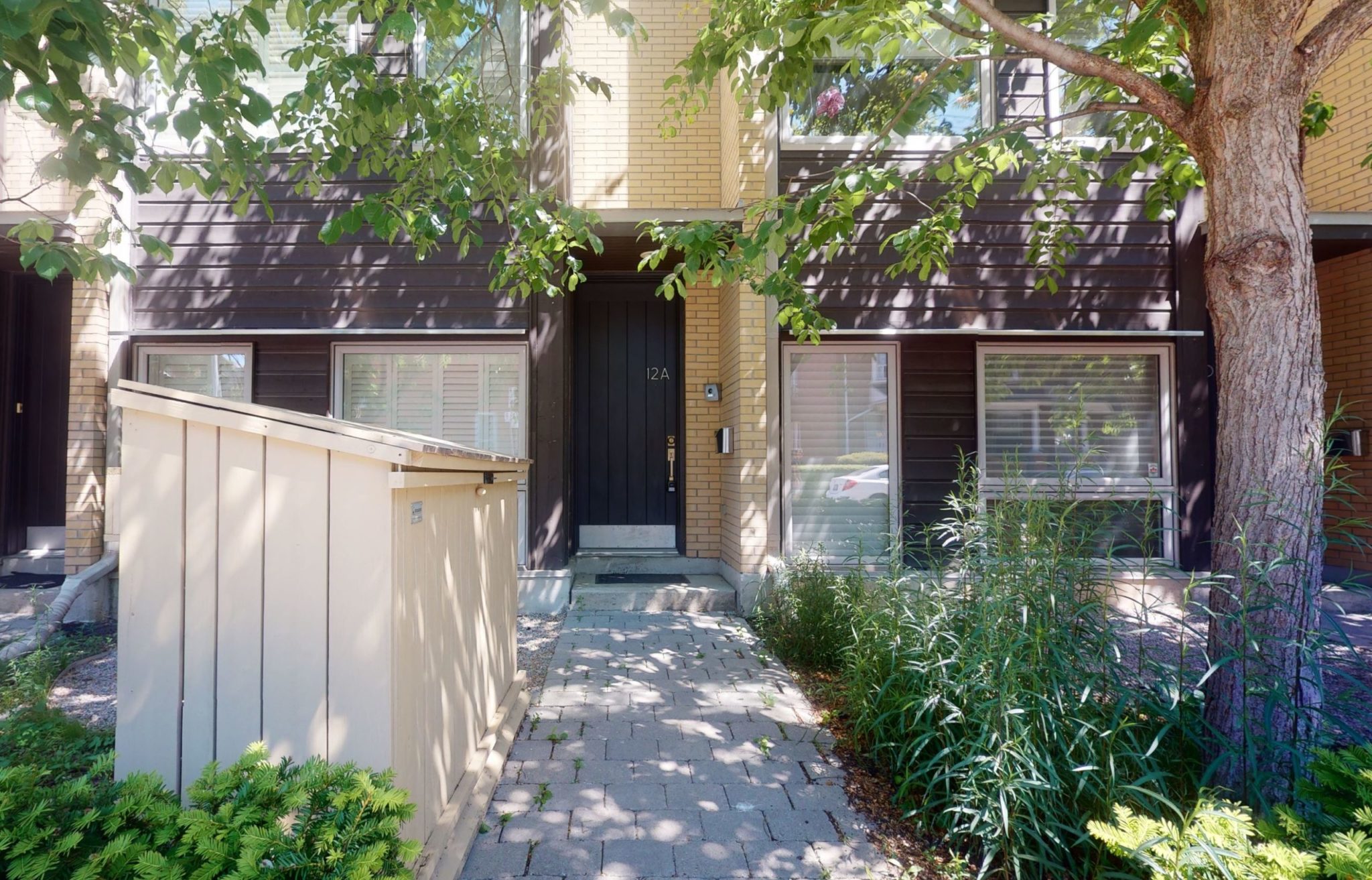 Front entrance of 12A Cecil St, a dark-brick 3-storey condo townhouse.