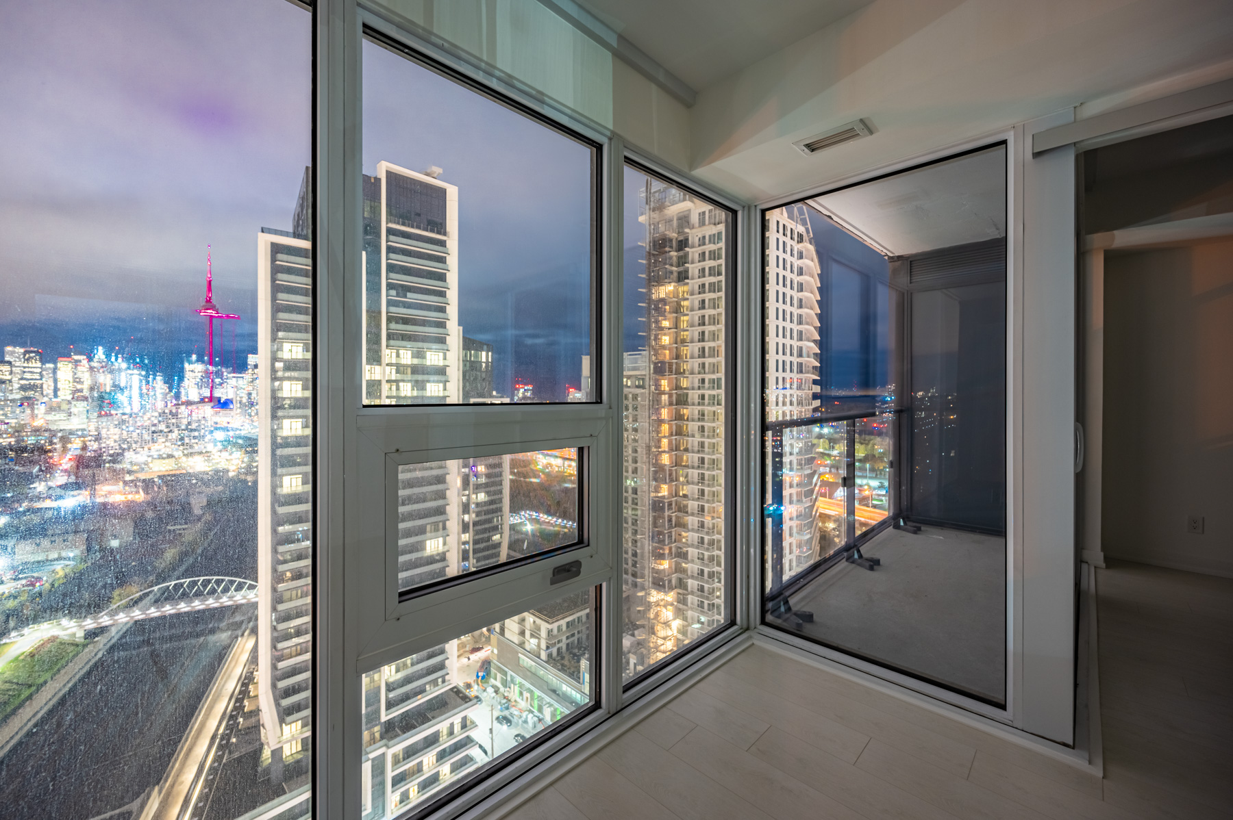 View of Toronto at night through windows of 19 Western Battery Rd bedroom.