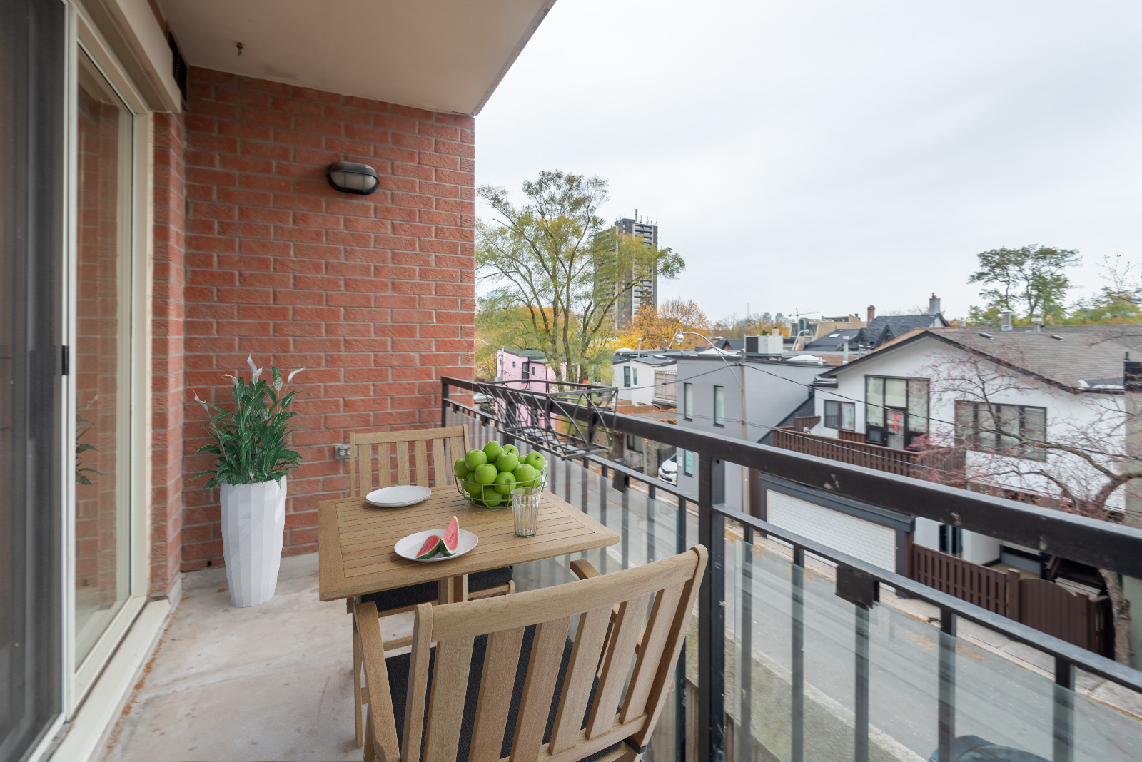 Balcony view of Yorkville streets from McMurrich Residences with 3D table and chairs and fruit.