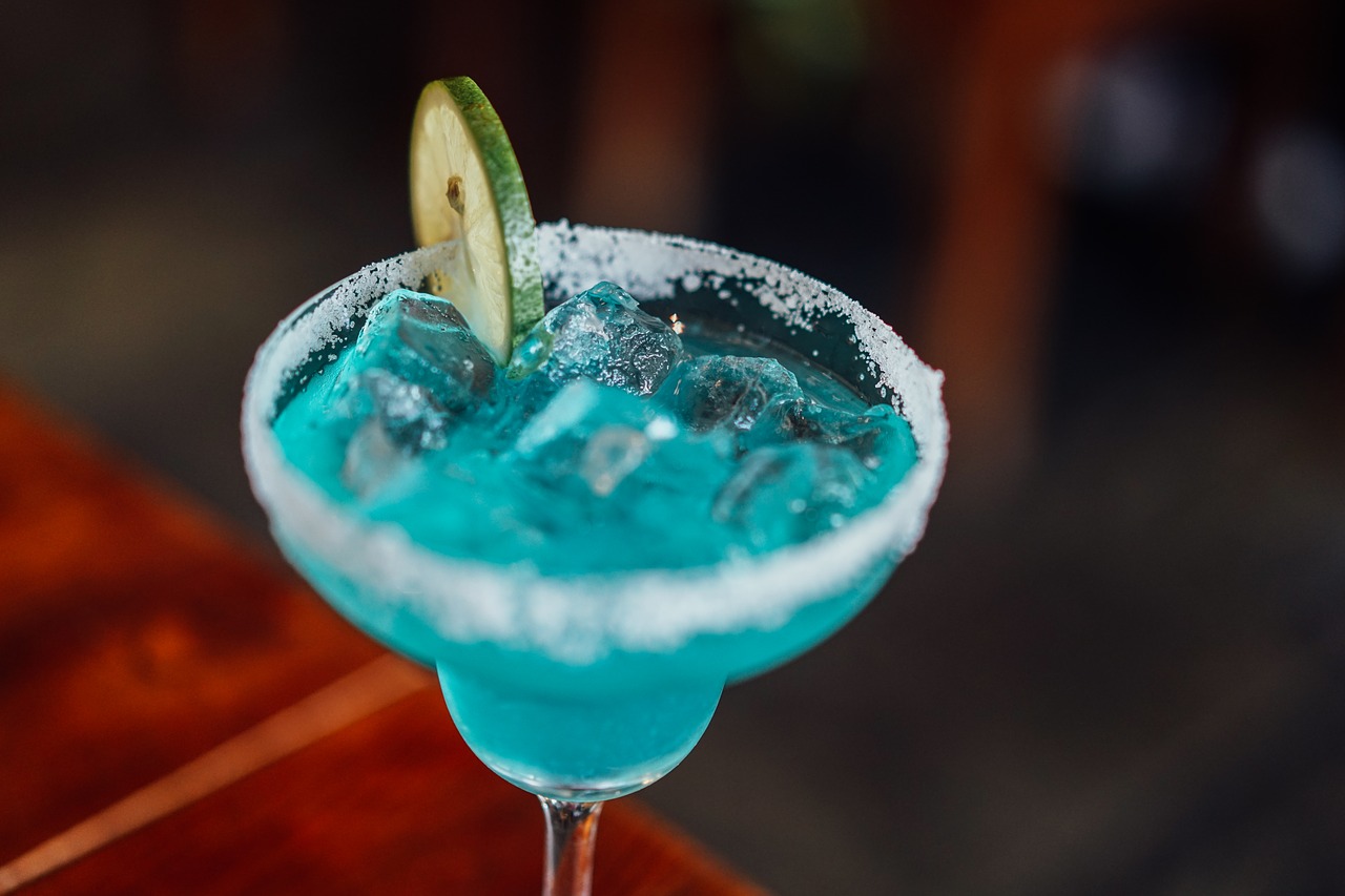 Cocktail glass with salted rim and blue liquid closeup.