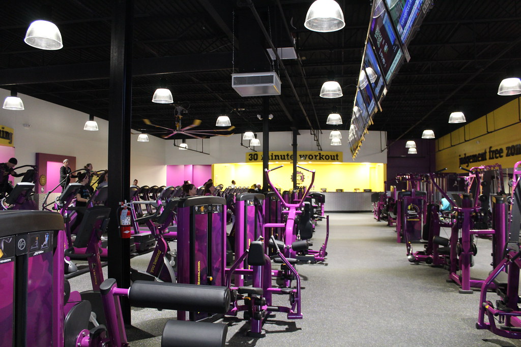 Planet Fitness purple gym equipment, yellow walls and huge lights.
