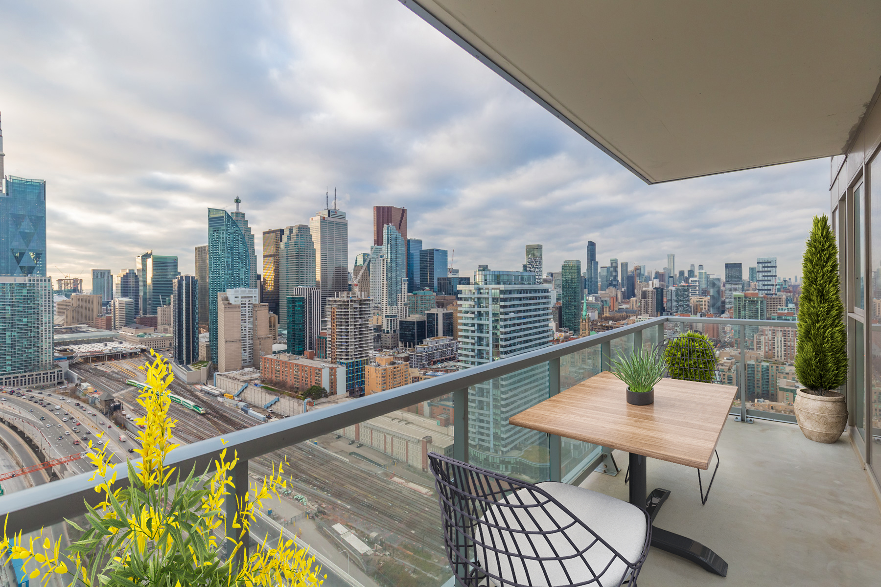 20 Richardson St balcony with glass panels and virtually staged patio furniture.