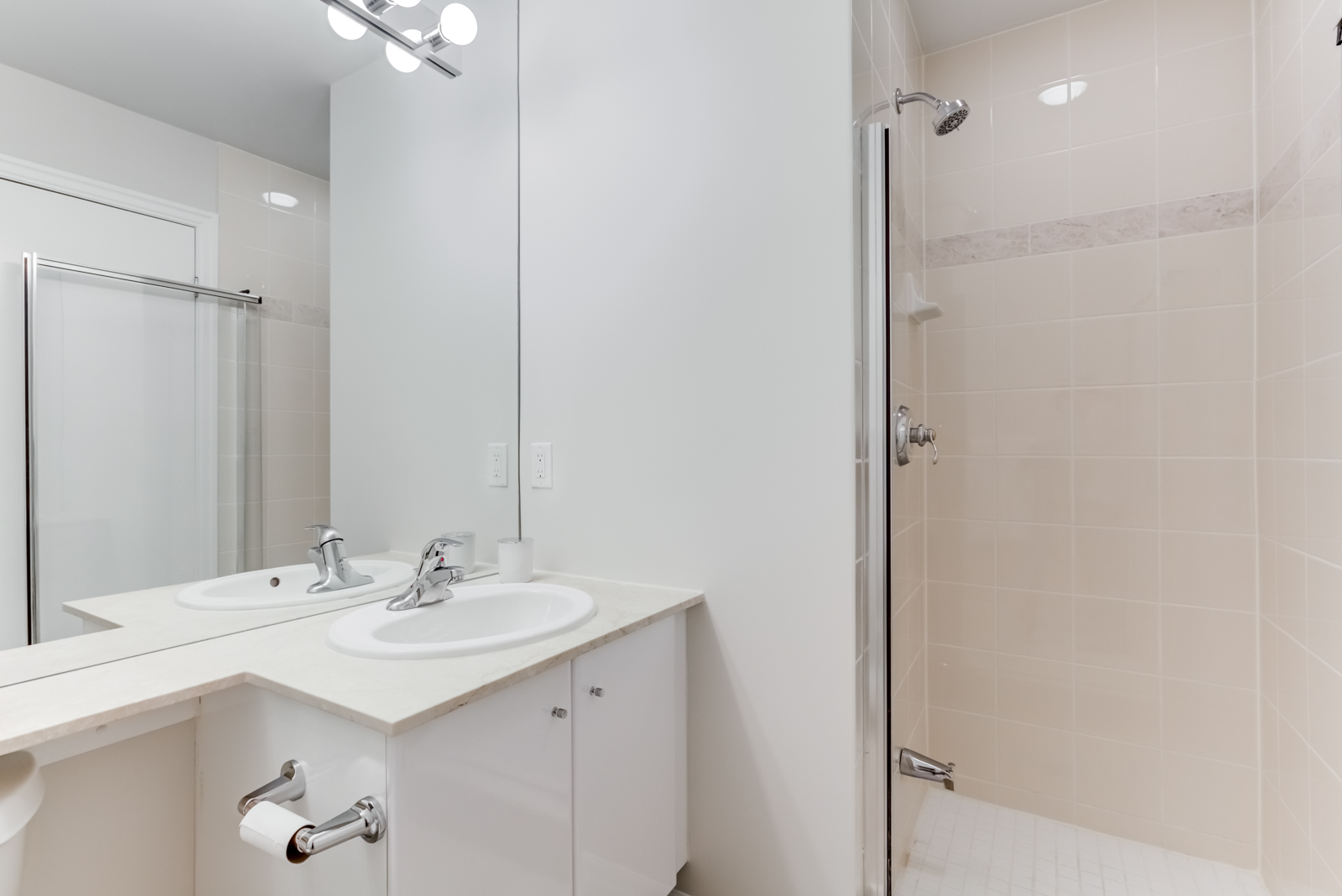 Small bathroom with walk-in shower, chrome fixtures, beige tiles and white counter-tops.