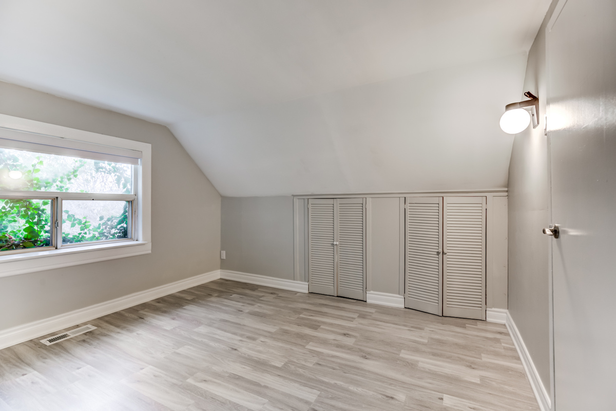 Empty master bedroom with two small closets.