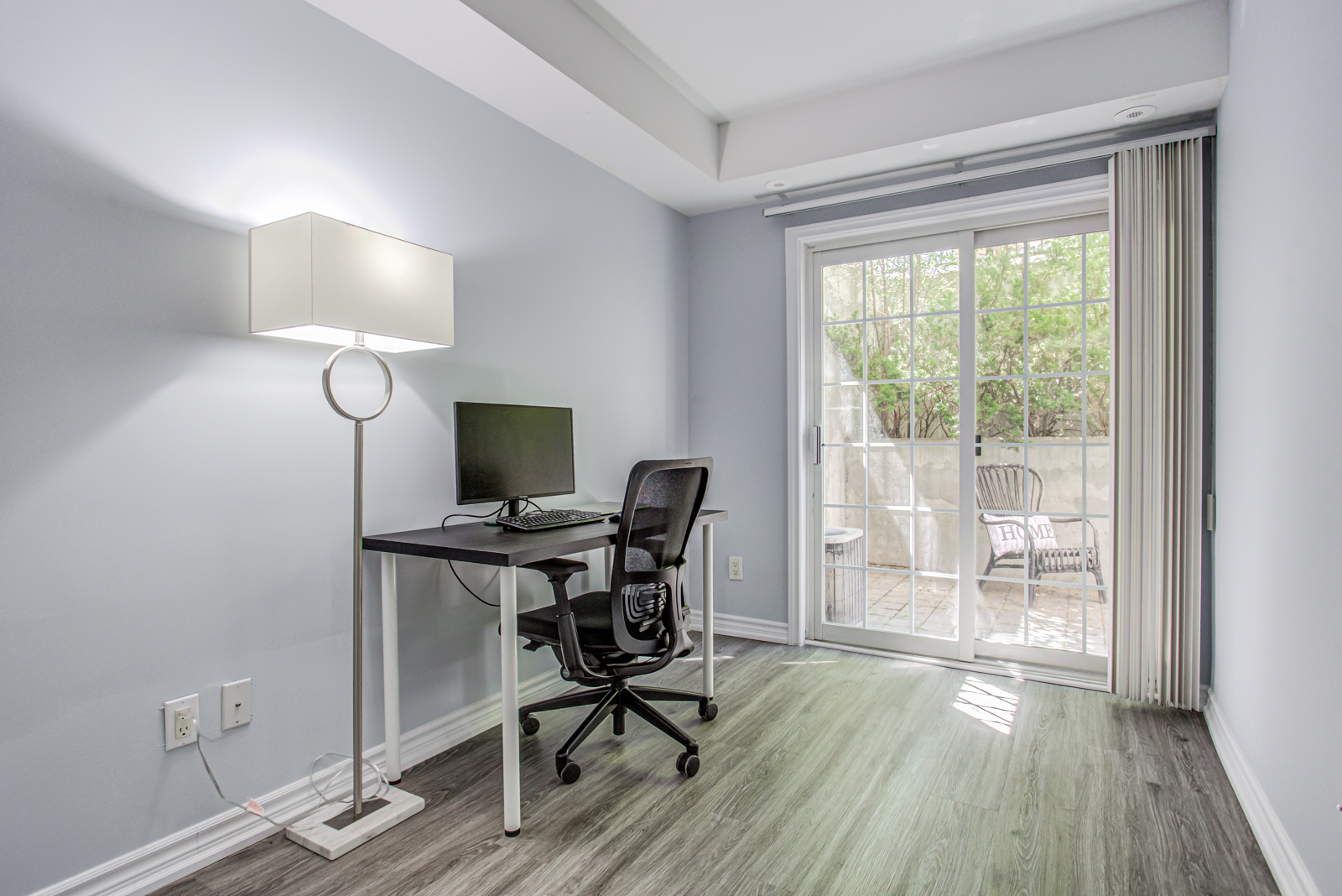 Second bedroom of 1563-5 Everson Dr with office desk, chair, lamp and view of patio.