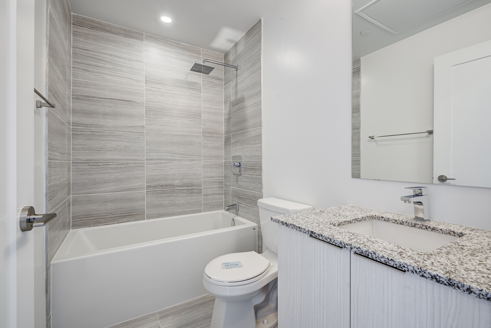 120 Parliament St Unit 1610 bathroom with dark tiles, gray walls and soaker tub.