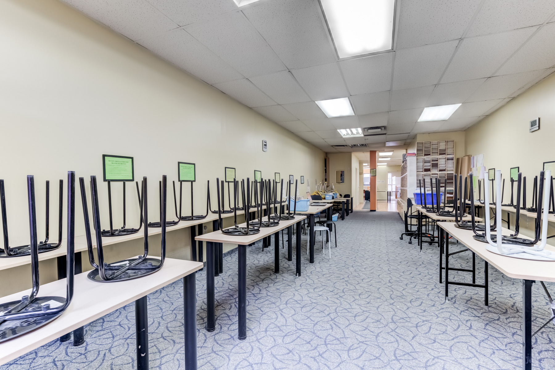 Empty classroom with chairs stacked on tables.