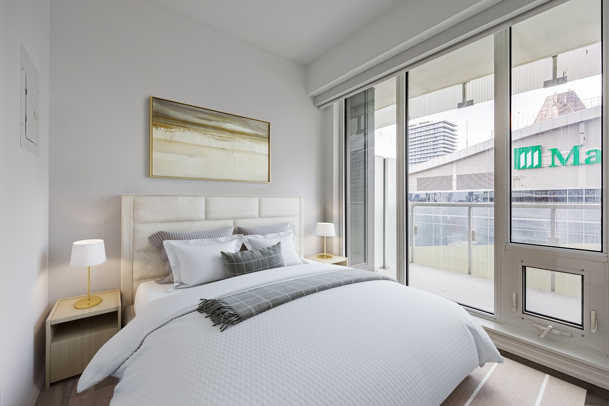 Condo bedroom with large bed and two side tables.