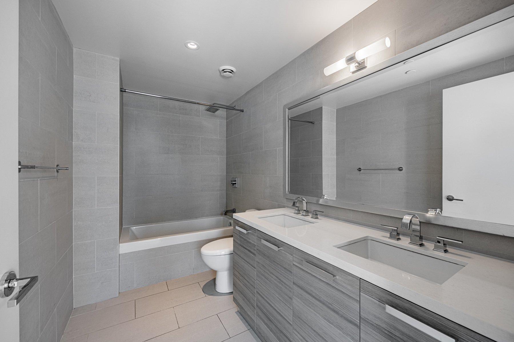 Huge ensuite bath with porcelain floors, dual sinks, stone counters & soaker tub.